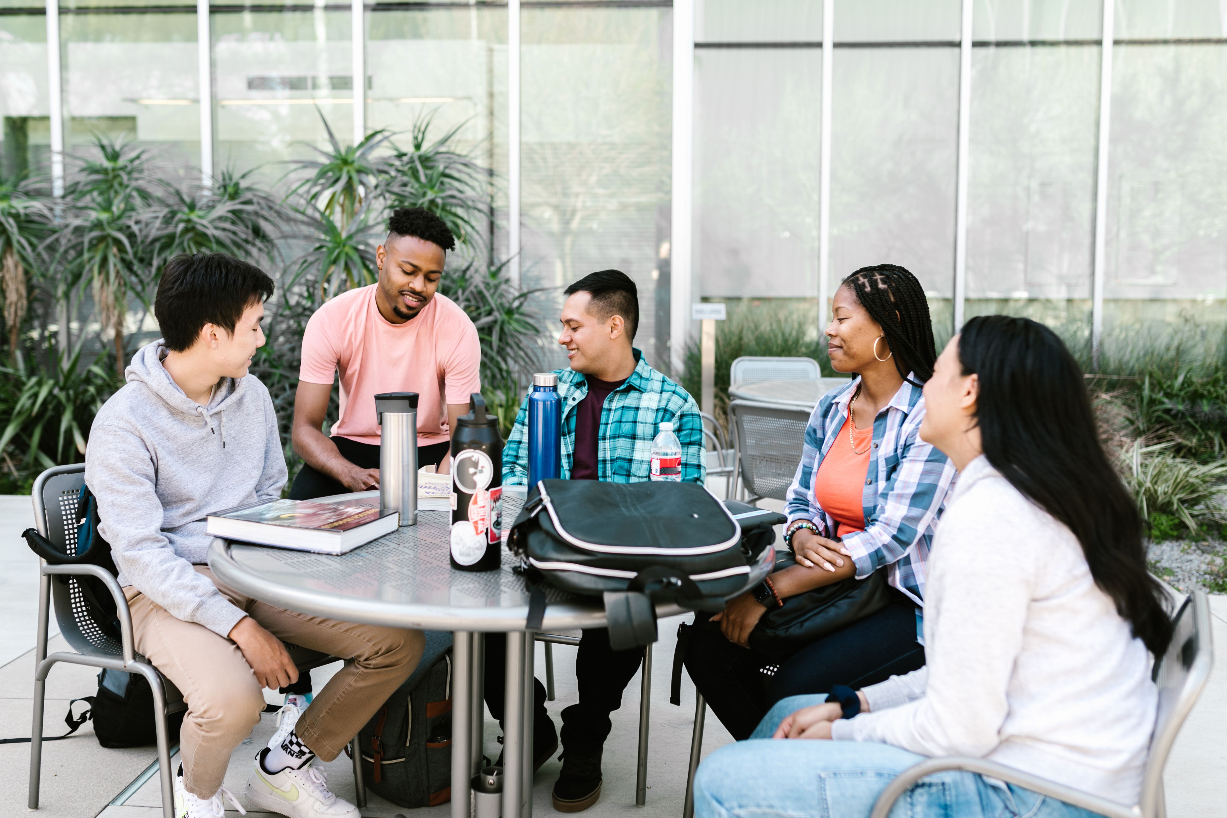 Group of students and teachers talking around a table